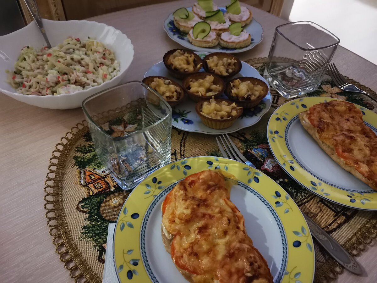 Пример ужина на двоих: салат из кальмаров, гренки из белого хлеба с пастой из морепродуктов с огурцом, жюльен, запечённый в тарталетках и свиная отбивная под шубкой.