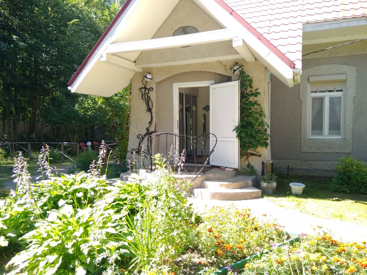 Вход в папин пансионат. На зеленой территории с фонтаном  расположился небольшой двух-этажный домик. По периметру- забор. 