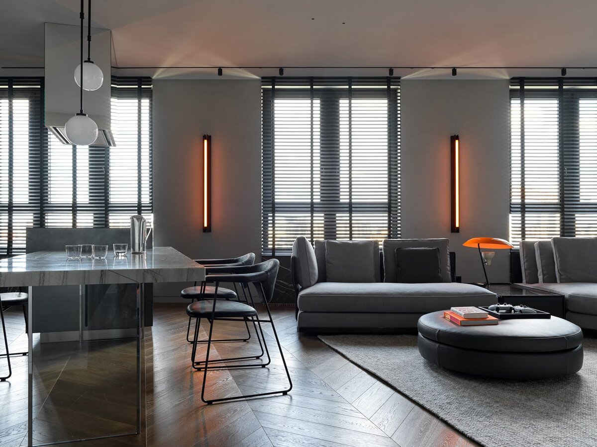 Фото: Сергей КрасюкЗона гостиной.  Диван, пуф и приставной столик Minotti, бра Pelle, настольная лампа Astep, ковер Armadillo & Co, книги Assouline, поднос Serax.