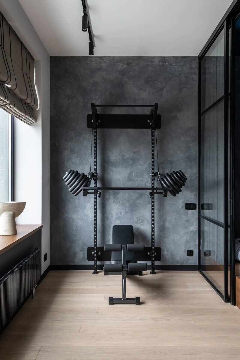 Рядом со спальней обустроили место для тренировок — установили стойку со штангой и турником. Эту зону выделили декоративной штукатуркой.