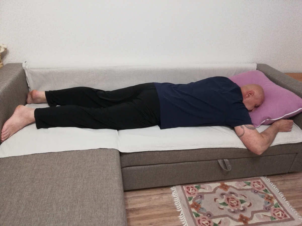 Лицом вниз - на подушку, подняв и слегка согнув руки в локтях, на уровне головы.