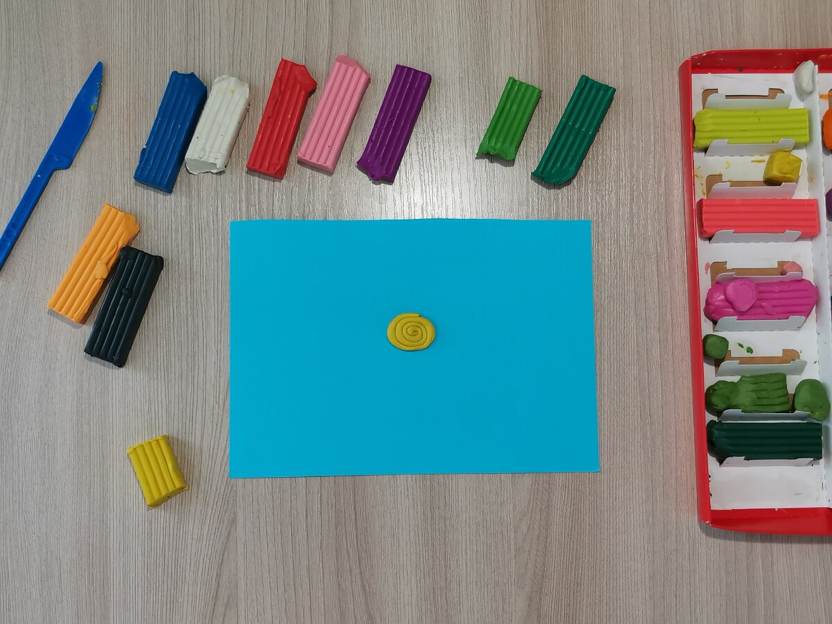 2 шаг. Начинаем делать раковину нашей улитке. Я взяла жёлтый цвет, раскатала длинную колбаску и свернула её в спираль. Затем прижала жёлтую спираль по центру листочка.