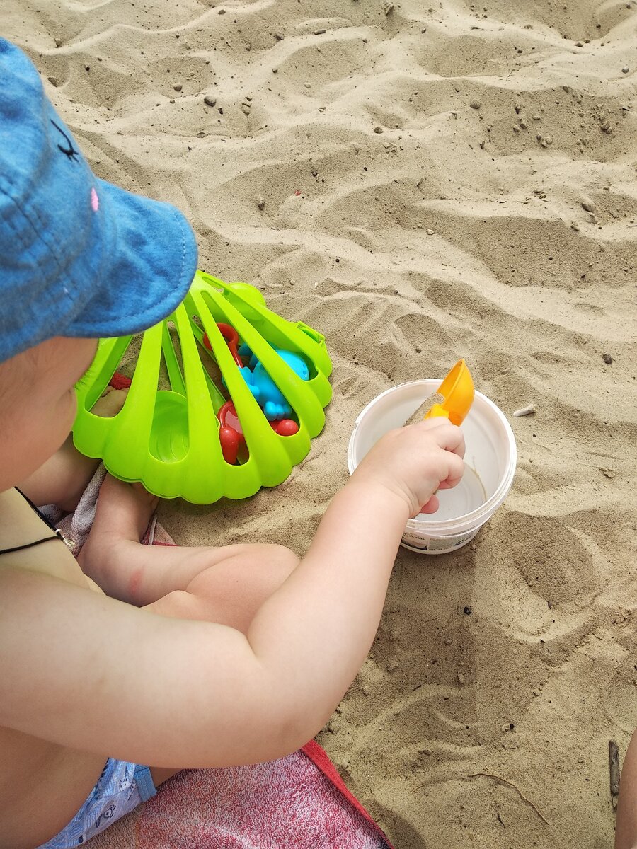 Насыпает песок в ведёрко