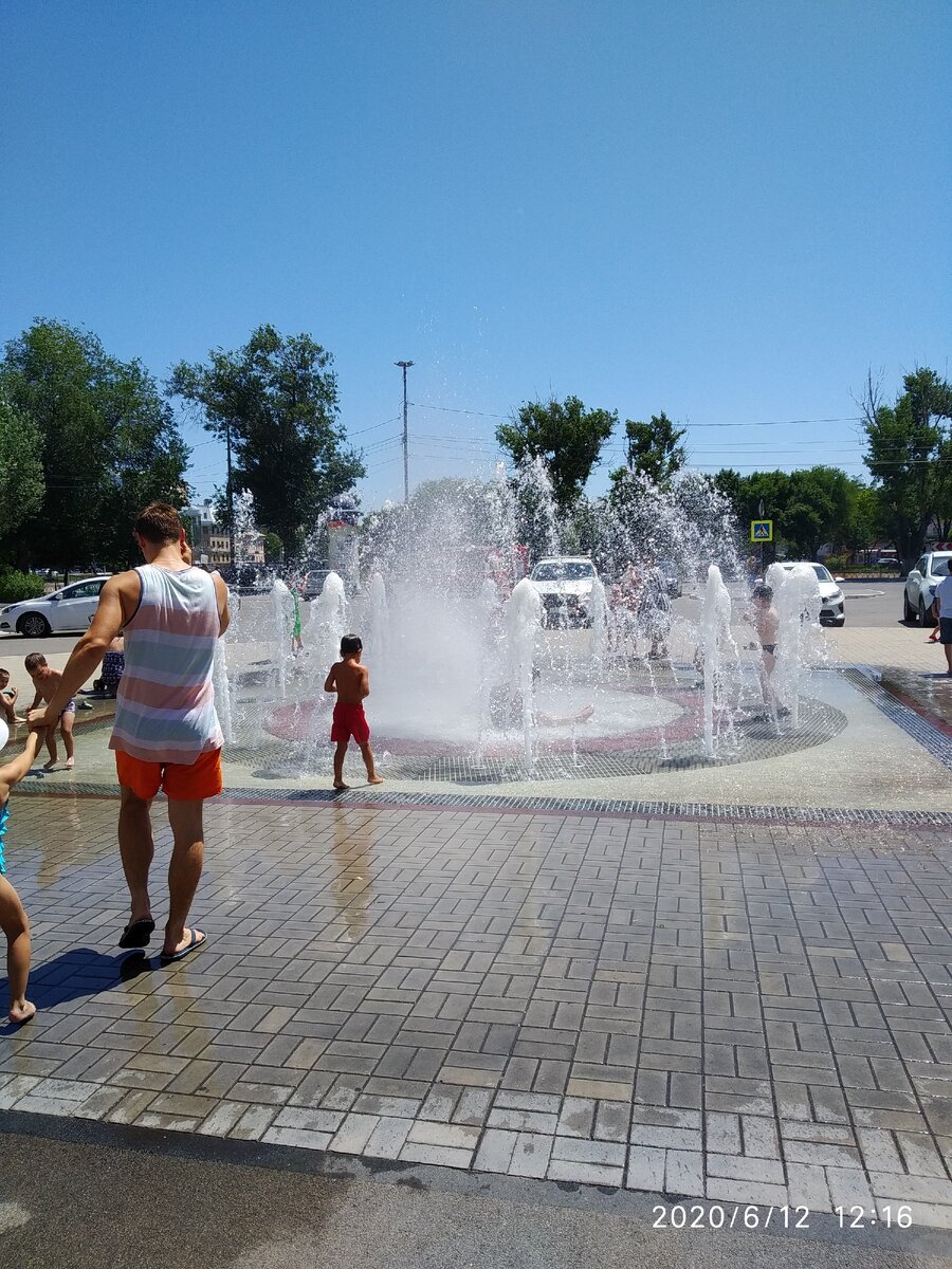 Дети резвятся в фонтанах.