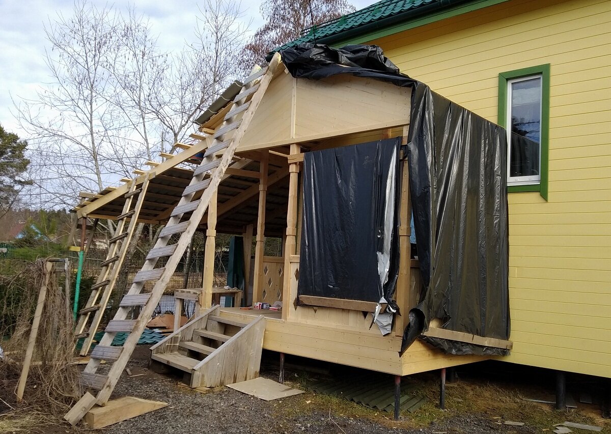 Вот так приходилось укрывать крыльцо, пока не смонтировали металлочерепицу.