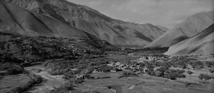 Типичная афганская река. По берегам видны кишлаки, обработанные поля и «зелёнка». Всё это обрамляют горы.