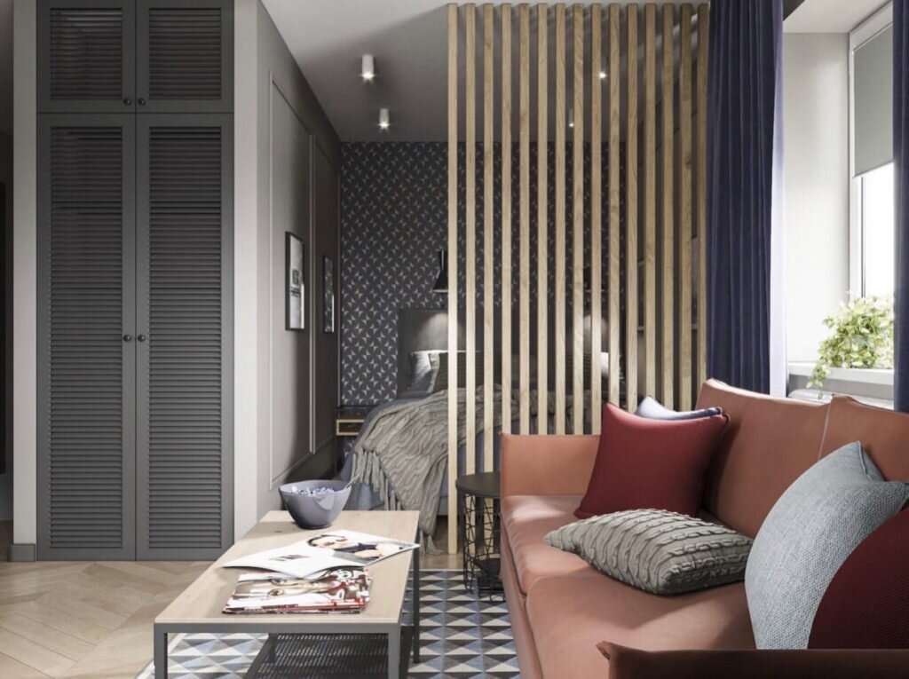 В этом интерьере комната визуально разделена рейчатой перегородкой. Такое решение позволило сохранить ощущение простора и более рацонально использовать площадь для размещения функциональных зон — спальни и гостиной.