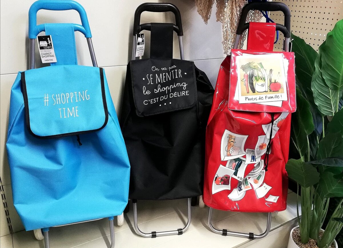 На сумке черного цвета написано: Не будем себя обманывать - шопинг - это бред  (однако слово délire можно также перевести как "исступленный восторг"). Фото автора