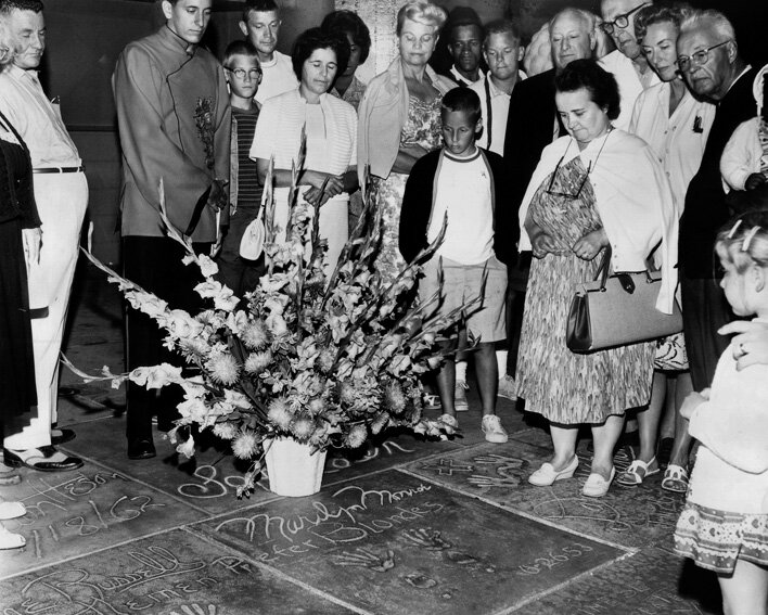 Фото у отпечатков рук и ног Мэрилин Монро вскоре после её смерти, 1962