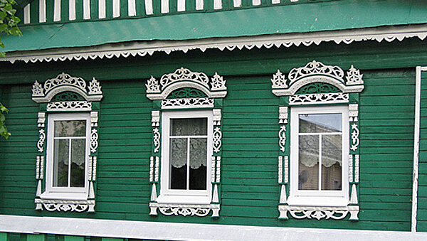 Фасад старого бревенчатого дома с пластиковыми окнами