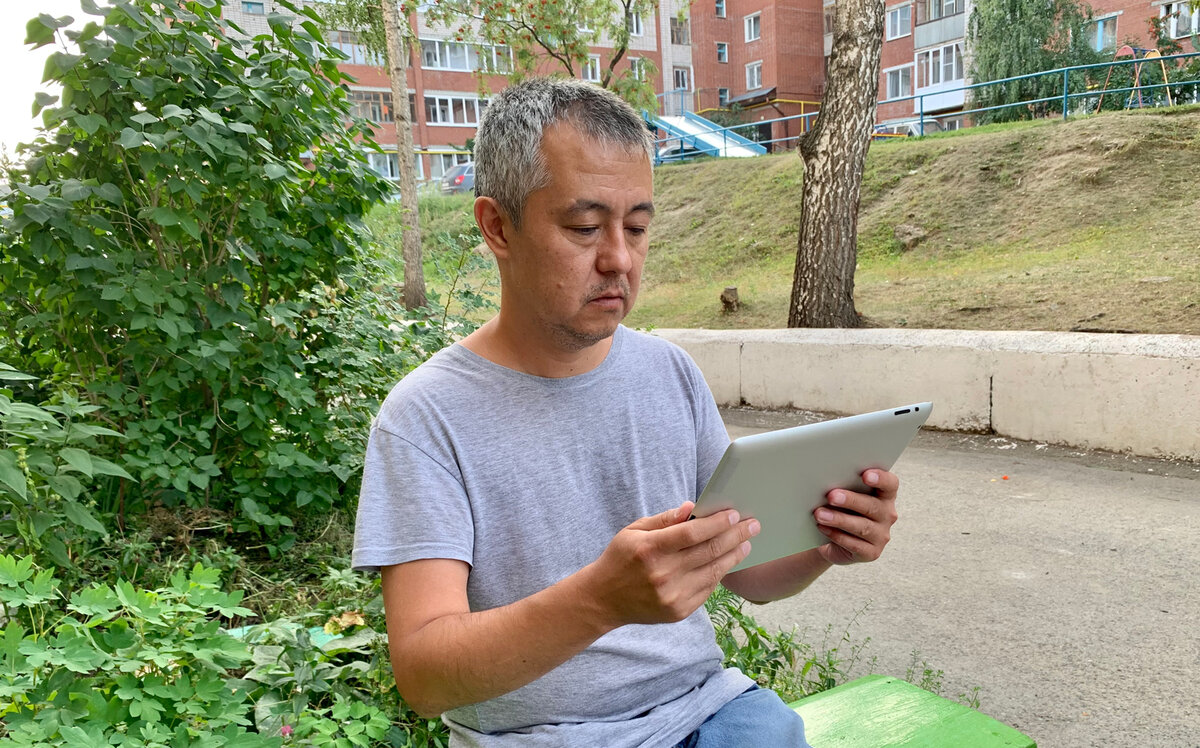 Сельский учитель следит за конференцией на планшете