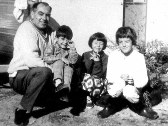 Джим Бомонт держит на руках Гранта, рядом с ним на корточках сидит Анна, а чуть дальше — Джейн