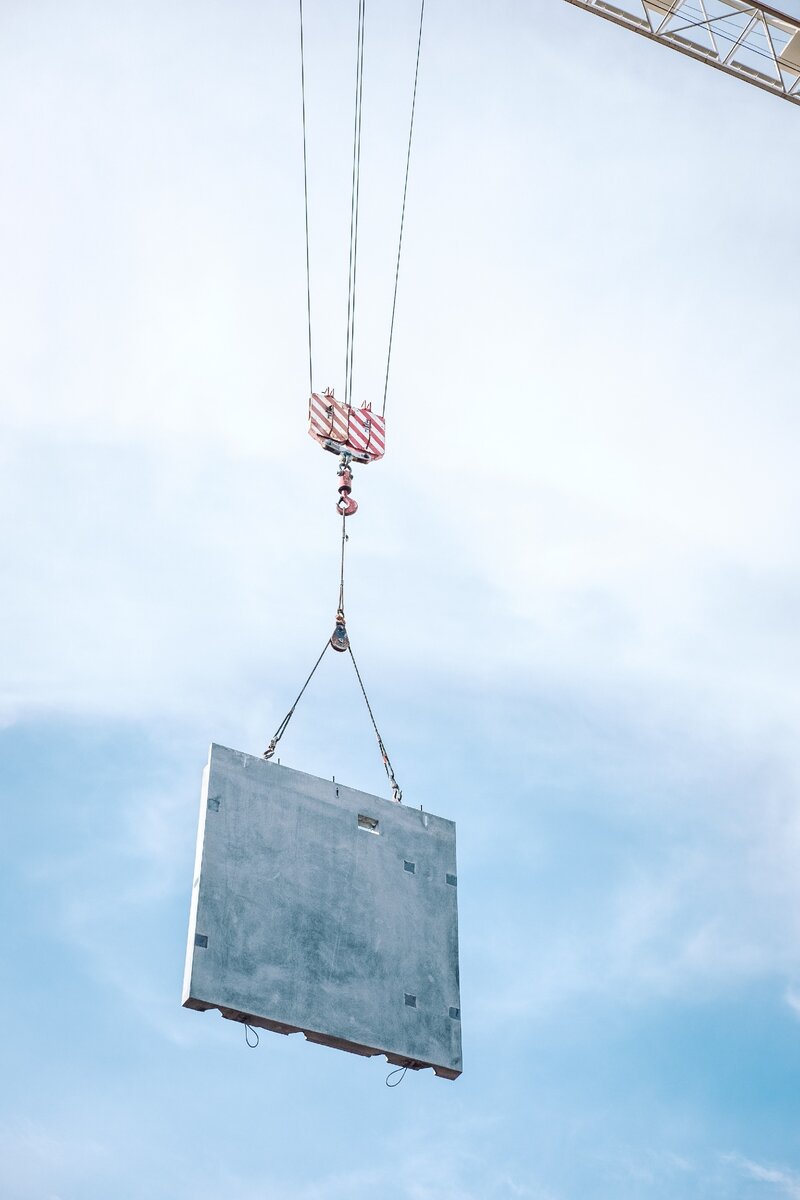 Crane is raising a plate - грузоподъемный кран поднимает плиту