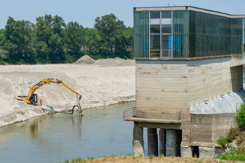 Экскаватор опускает уровень русла реки По, чтобы вода достигла гидравлических насосов ирригационной системы в Боретто, Италия, 17 июня.Фотограф: Франческа Вольпи/Bloomberg.