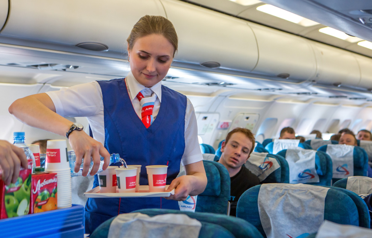 путешествие на самолете. образ в самолет. пассажиры на борту самолета. перекус в самолет. стюардесса с едой.