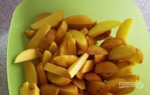 Картофель вымойте, очистите щеткой от грязи и песка. Затем разрежьте на небольшие дольки и промойте еще раз. Обсушите бумажными полотенцами. Если картофель молодой, то вы можете его не очищать от кожуры. 
