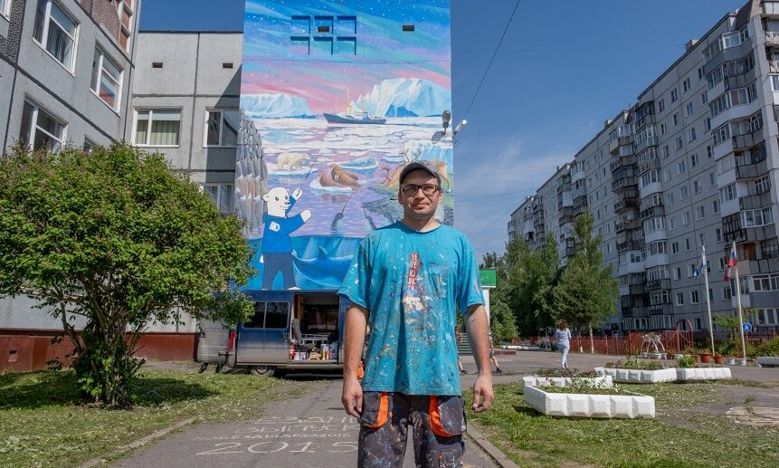 Александр Менухов на фоне своей работы