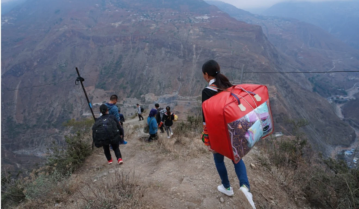 Сельские семьи идут к своим новым домам в уезде Чжаоцзюэ, юго-западной китайской провинции Сычуань.