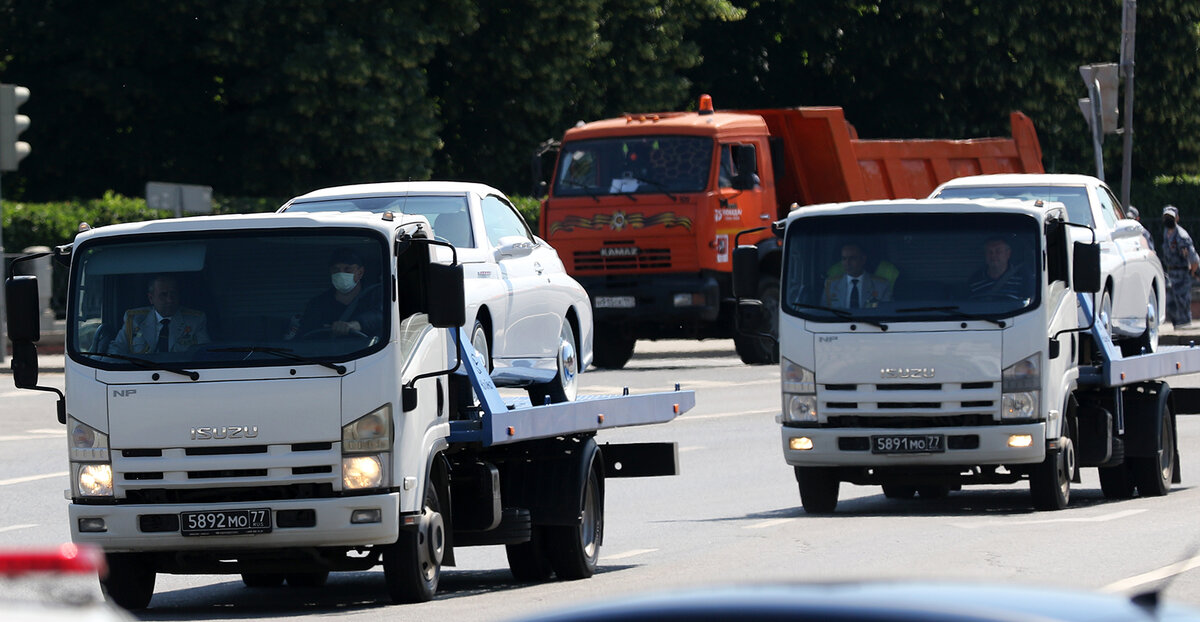после парада автомобили на эвакуаторах покидают Красную площадь в сопровождениии сотрудников министерства обороны Туркменистана 