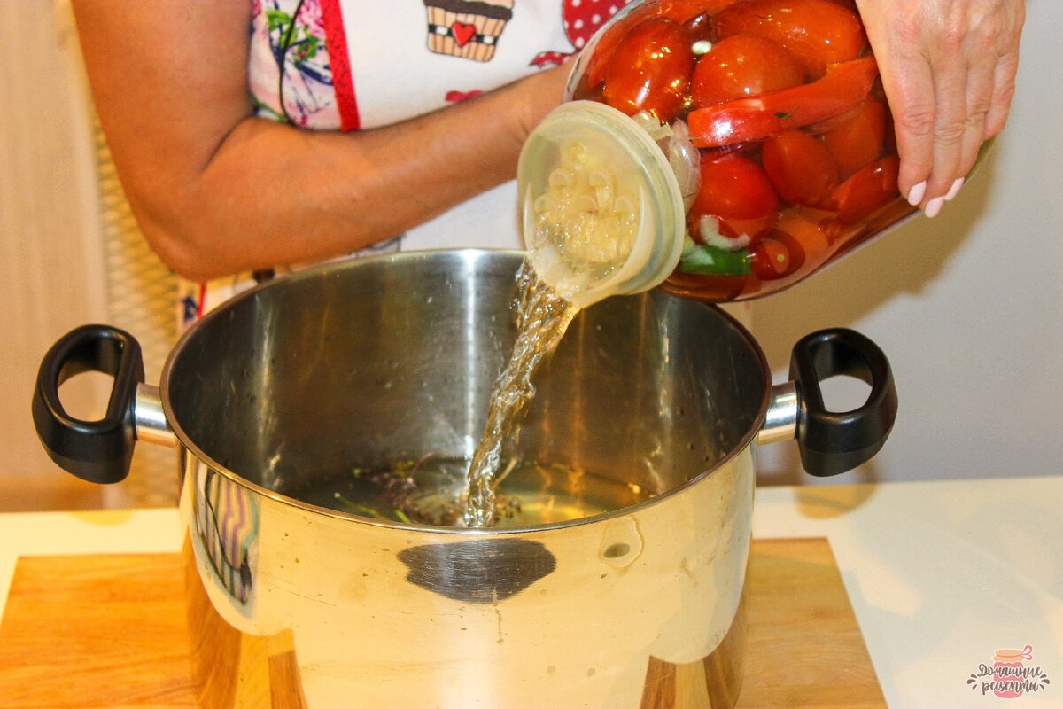 Воду сливаем из банок, она уже отдала тепло помидорам, удобно сливать если накрыть банку специальной крышкой с дырочками.