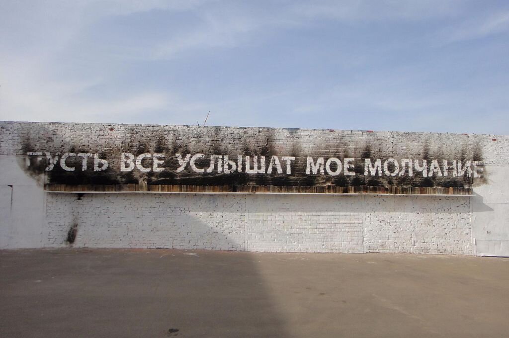 Автор: Тимофей Радя. На СТЕНЕ представлена полка с обгоревшими книгами — проводниками и спутниками культуры. «Пусть исчезнут слова и книги, но сохранится и трансформируется энергия, заключенная в них. Она останется на стене, новыми словами» — говорит художник о мечте преобразования разрушительной силы в силу созидательную.