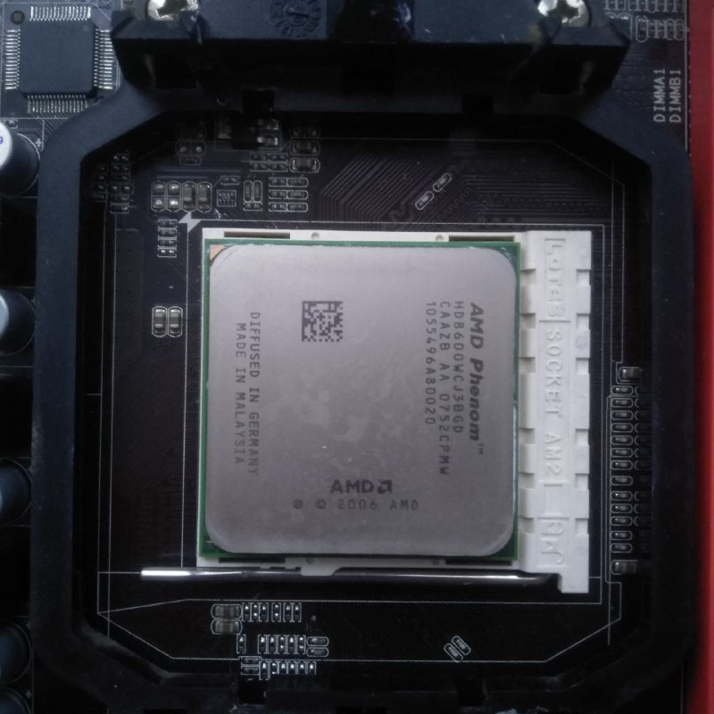 AMD. Процессор вставлен, рычаг опущен (треугольный ключ процессора слева сверху).