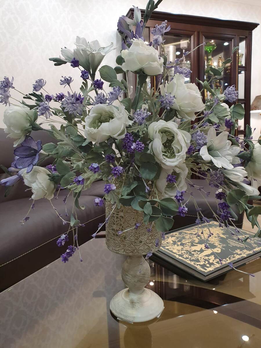 ...одной известной женщине запретили носить фиолетовый цвет… Только потому, что он ассоциировался с «цветом монархов».

Этой женщиной была актриса Элизабет Тейлор, а история разворачивалась во время предвыборной кампании её седьмого мужа, сенатора США.

Власти забеспокоились, что эта роскошная дама, сыгравшая роль египетской царицы Клеопатры, заберет все голоса, просто надев платье королевского цвета.

Правила есть правила. И на период гонки кандидатов в сенаторы, Элизабет Тейлор покорно подчинилась.
Но, когда все закончилось, она «оторвалась» и надела брючный костюм Halston самого ядреного фиолетового оттенка.
Когда я прочитала эту историю, внутри все протестовало.

Что за предрассудки?
Я бы так не смогла.
Тем более, что фиолетовый – один из моих любимых цветов.
Он покорил меня еще во Франции, когда я впервые увидела лавандовое поле.
Красота невероятная.
Чувствуешь спокойствие и умиротворение.
Это именно тот цветок, который должен быть в доме, – отметила я тогда для себя.

А спустя много лет в моей коллекции появился букет из шелка «Прованс».

В нем фиолетовые веточки лаванды выглядывают со всех сторон и напоминают звездочки.
А горные воздушные цветочки торжественны в своей шелковой юбочке и кокетливо возвышаются над горделивыми фрезиями. По соседству с ними властвуют королевские белые розы.

Весь букет создает ощущение прохлады и свежести. Пространство вокруг озаряется светом, наполняется теплом и уютом.

И мне кажется, что, если бы букет «Прованс» тогда появился в интерьере Тейлор, это была бы для нее своеобразная поддержка духа. Маленький знак протеста против глупых запретов.

А какой ваш любимый цвет? Смогли бы смириться, если бы вам запретили его носить?