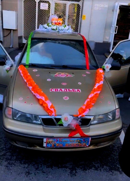 Даже не верится, но именно эта Нэксия везла пару в ЗАГС. Молодожены садятся сначала в украшенный свадебными лентами старый седан Daewoo Nexia, который рэпер в комментариях назвал «легендарной тачкой».