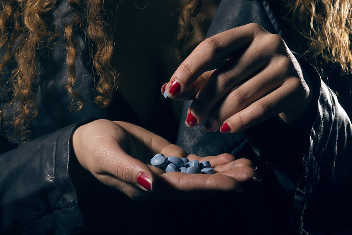 Фото таблеток в руке у девушки в темноте фото