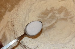 Муку просеиваем на стол, делаем небольшой колодец. В середину углубления всыпаем соль.