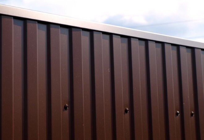 Внимание! Декоративная планка бессмысленна, когда сооружается временное ограждение либо каркасом забора является стальная рама. Для первой ситуации дизайн несущественен, а при наличии рамы именно она защищает надежно листы.
 
 