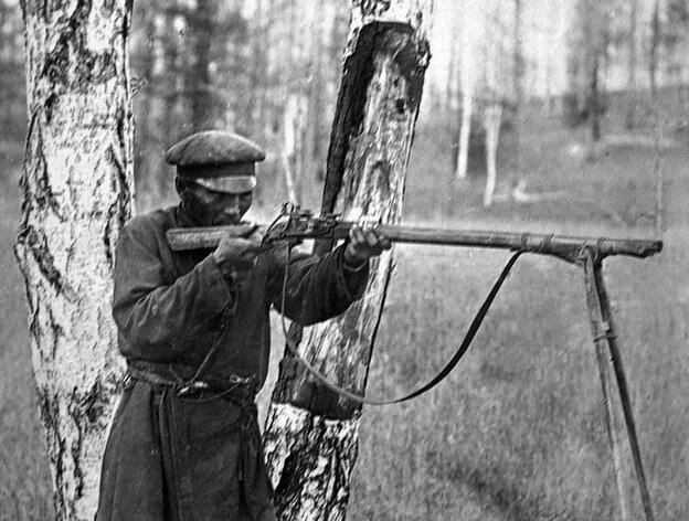 Вот еще подобная конструкция: кремневое ружьё (или даже фитильное) с примотанными сошками в рост человека. Судя по березам, это уже средняя полоса или даже Северо-запад... Возможно, Архангельская область или Вологодская область.