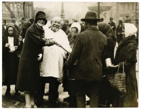 дядя Роберт (в белой рубахе) раздаёт еду нуждающимся