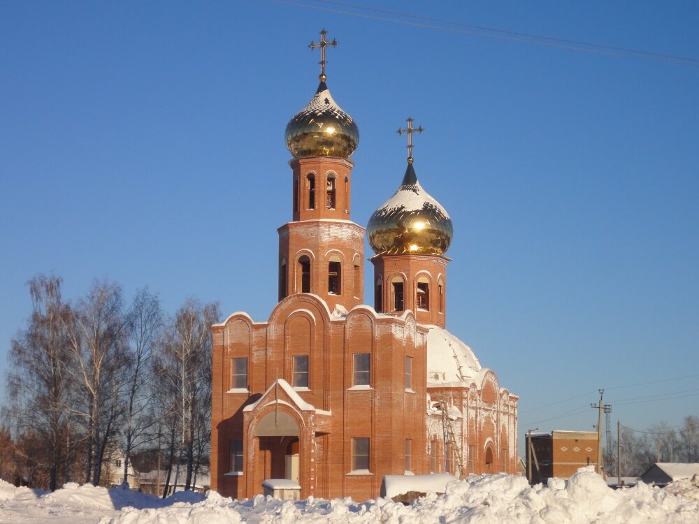 Кирпичный храм с черными куполами