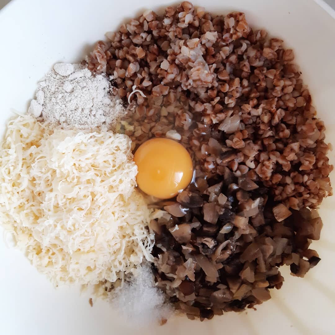 Шампиньоны, лук мелко нарезать и потушить, остудить. Сыр натереть на мелкой терке. Затем добавляем грибы с луком, натёртый сыр, яйцо, муку, специи к грече и тщательно перемешиваем, лучше руками или немного погружным блендером.