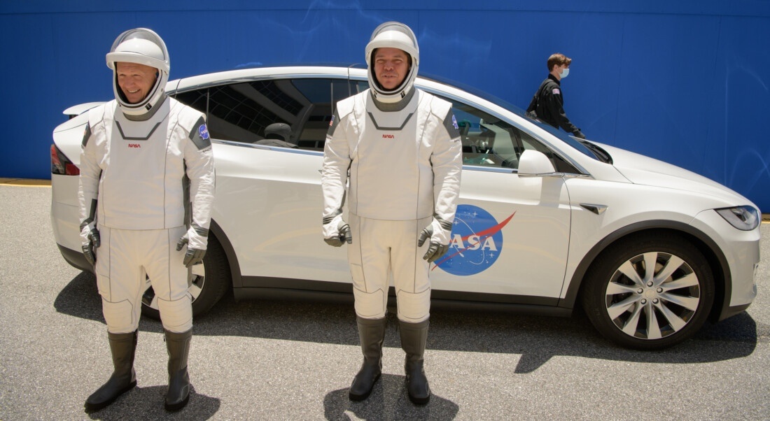 Немного забавные костюмы и Tesla на заднем фоне.