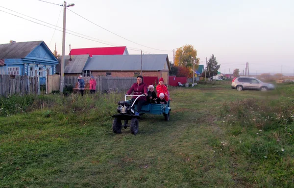 Ляля везёт детей из школы на мотоблоке. Фото автора. Слева мой дом...