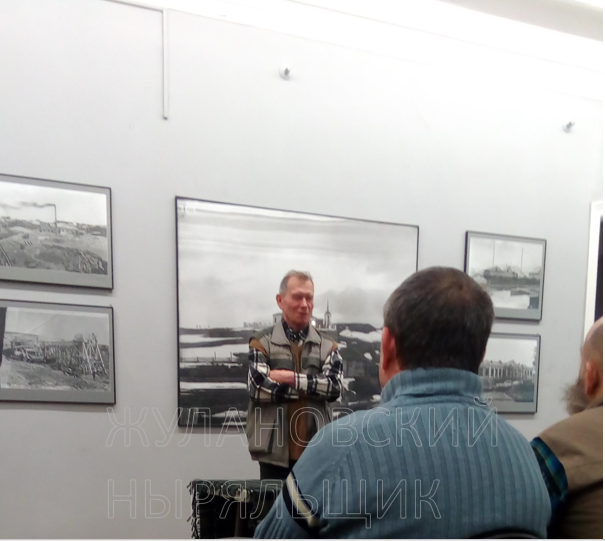 Бирюков Е.М. читает лекцию на фоне фотографий Метенкова