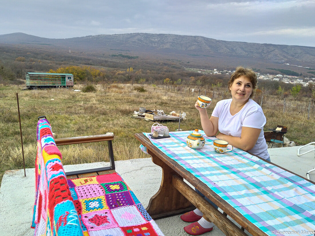На фото: это Ольга, пьет чай на веранде своего старокрымского домовладения; за спиной у Ольги виден городок Старый Крым и гора Агармыш.
