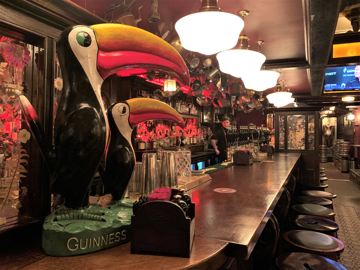 Барная стойка на первом этаже и фирменные туканы Гиннесса