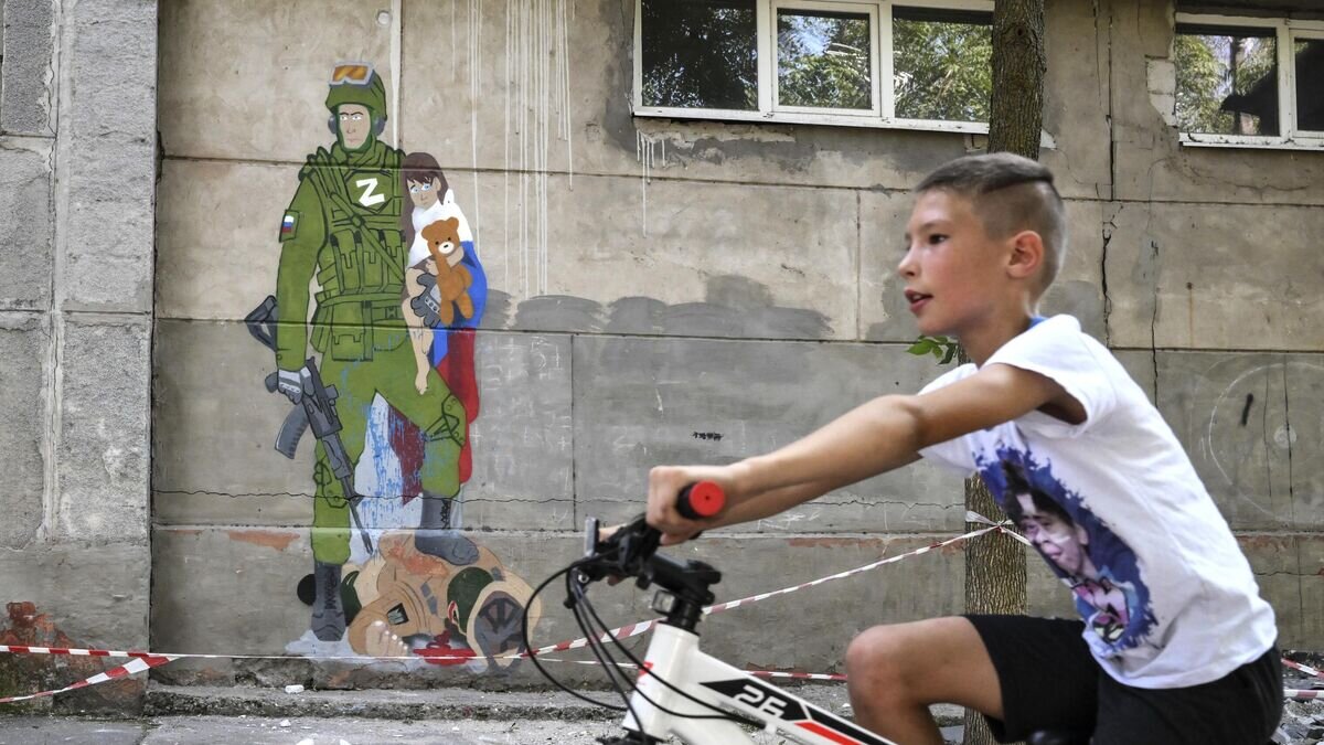    Граффити на стене средней школы №5 в Мариуполе© РИА Новости / Илья Питалев