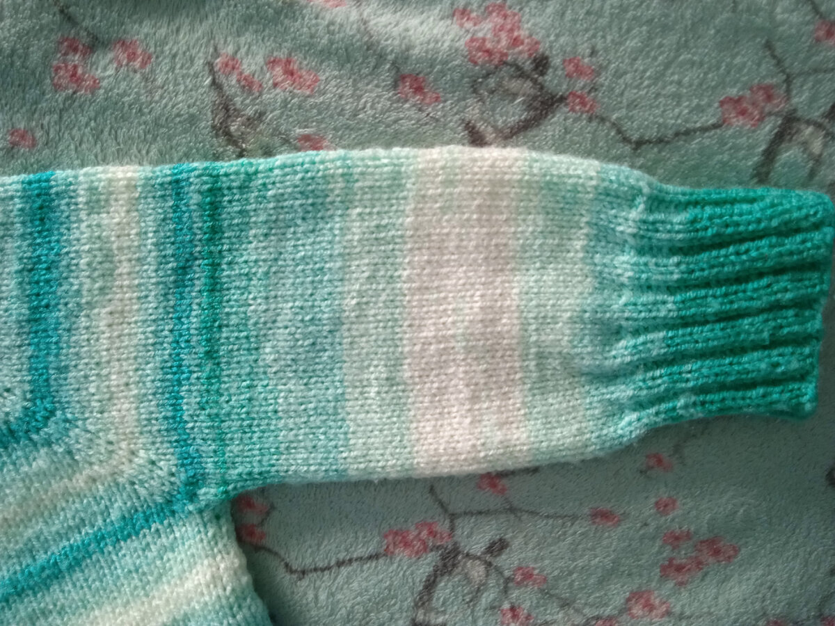 При вязании одним диаметром спиц рукав после реглана получался более узким. А на фото разницы нет, так как использавались разные спицы. 