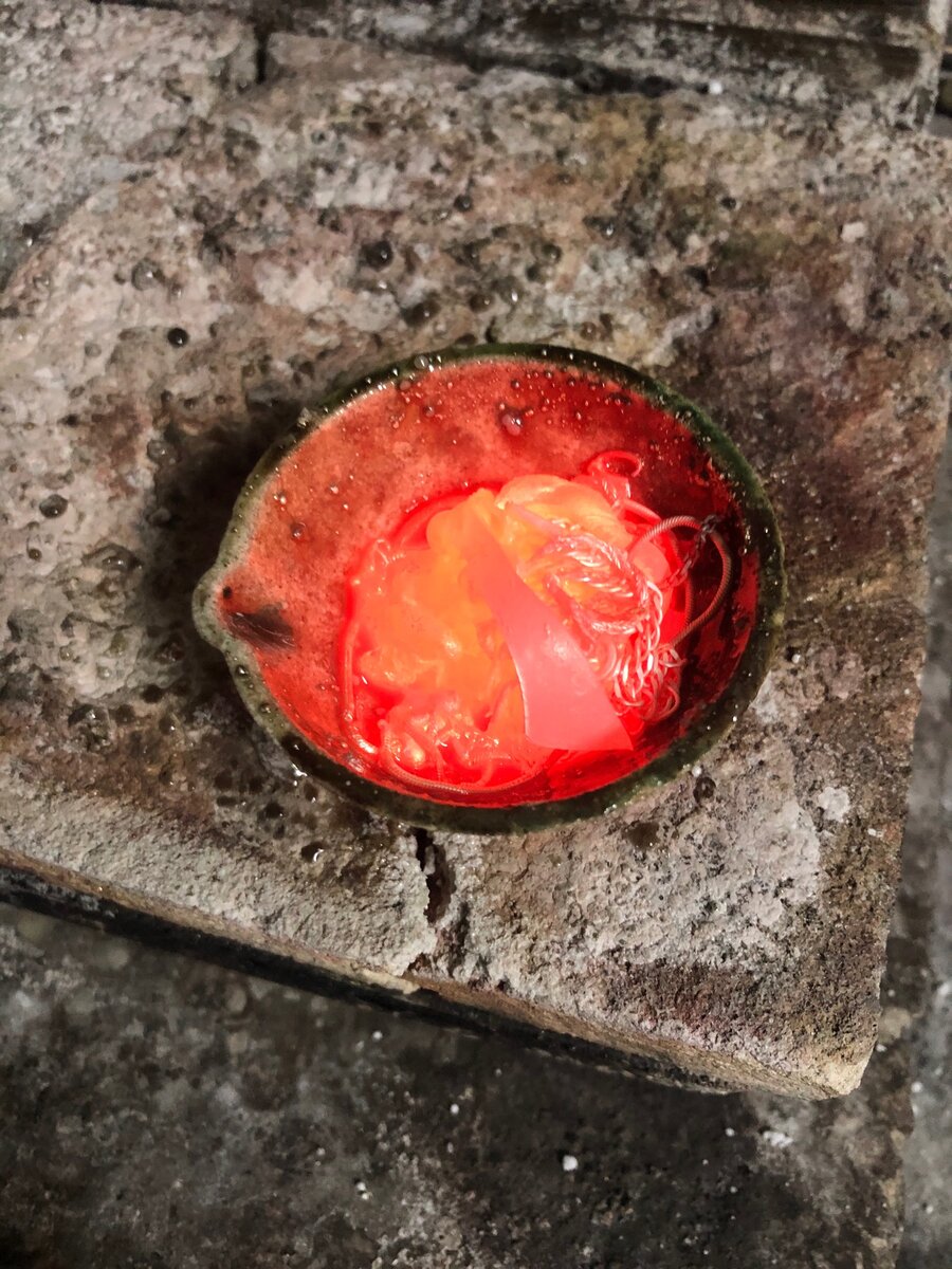 В тигле видно начинающие плавиться куски, остатки изделий.