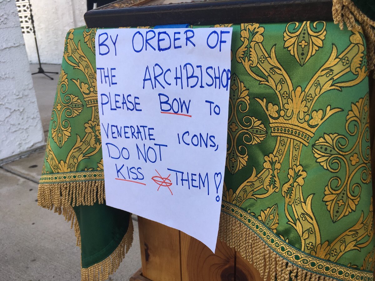 "По указу архиепископа, пожалуйста, поклонитесь перед иконами. Не целуйте их!" Даже перечёркнутый символ нарисован для тех, кто не понимает слов. Однако даже этот знак не всем указ. Фото автора. 