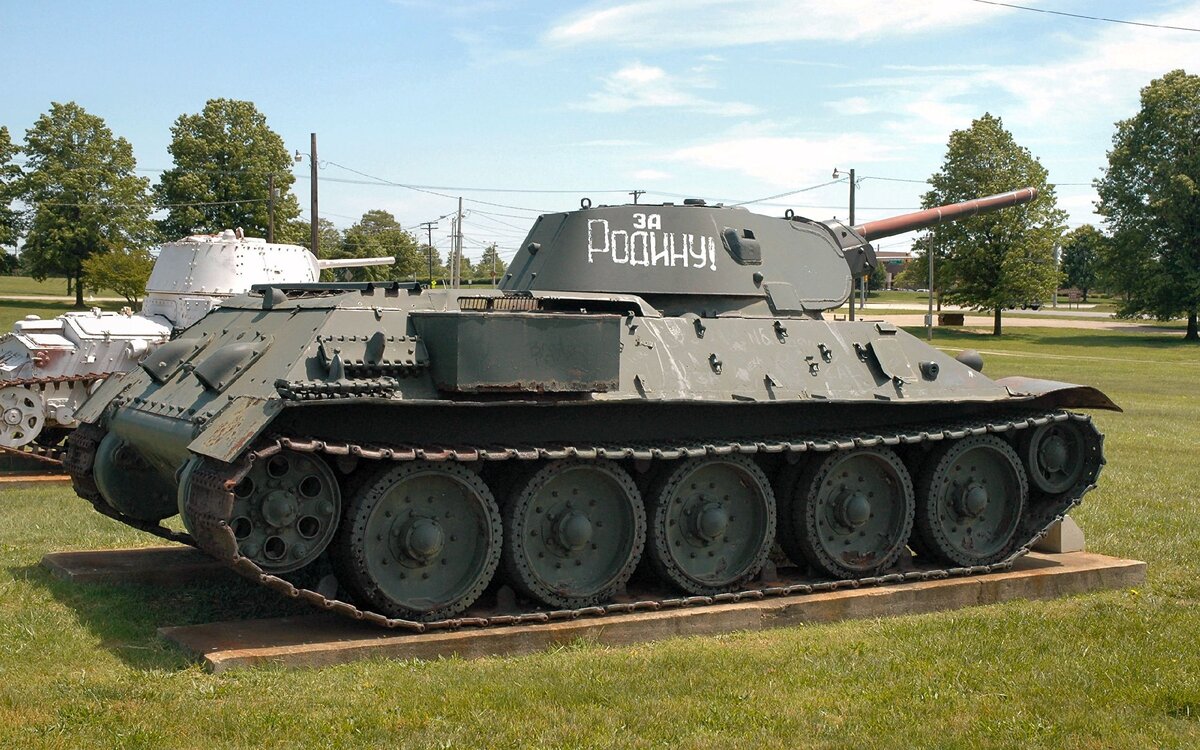 Самый массовый танк Второй мировой войны и послевоенного времени.

Разработан конструкторским бюро танкового отдела Харьковского завода № 183 под руководством Михаила Ильича Кошкина. Успешность проекта была предопределена применением новейшего высокоэкономичного дизель-мотора В-2, благодаря которому средний толстобронированный Т-34 унаследовал от лёгкого тонкобронированного БТ необычайно высокую удельную мощность (отношение мощности двигателя к боевой массе), обеспечившую в течение всей Великой Отечественной войны абсолютное превосходство танка Т-34 в проходимости, манёвренности, подвижности. Впервые в практике мирового танкостроения на среднем танке Т-34 была установлена длинноствольная (30,5 калибра) 76-мм пушка Л-11 (образца 1939 года), значительно превосходящая по начальной скорости бронебойного снаряда (635 м/сек) все существовавшие в те годы зарубежные танковые артиллерийские системы. А с марта 1941 года на Т-34 стали устанавливать 76,2-мм пушку Ф-34 (образца 1941 года) с длиной ствола 41,5 калибра и начальной скоростью бронебойного снаряда 662 м/сек, который пробивал 60-мм броню с дистанции 1000 м: Т-34-76 — уточняющее обозначение этой модели. Очень важным оказался высокий модернизационный потенциал конструкции, это позволило эффективно повышать боевые качества танка одновременно с наращиванием его промышленного производства в течение всей войны. С 1942 по 1945 годы основное крупносерийное производство Т-34 было развёрнуто на мощных машиностроительных заводах Урала и Сибири, и продолжалось в послевоенные годы. Ведущим заводом по модифицированию Т-34 являлся Уральский танковый завод № 183. Последняя модификация (Т-34-85) состоит на вооружении некоторых стран и по сей день.