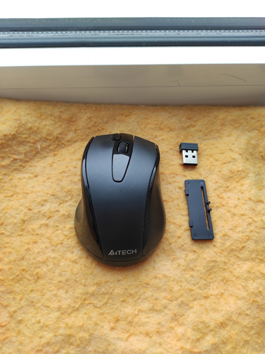 Части мыши состоят из блютус адаптера (справа сверху), который вставляется в ноутбук на USB вход, крышки батарейного отсека и самой основной части мыши