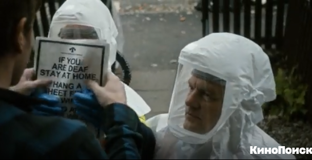 Кадр из фильма "Последняя любовь на земле". Общая суть надписи на листовке - "Если вы оглохли, оставайтесь дома, покажите некоторый знак и вам принесут еды"