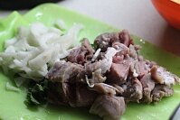 Сперва следует нарубить все ингредиенты блюда. Нужно измельчить крупными полукольцами очищенную репчатую луковицу, мелко нашинковать стебли и зелень сельдерея, нарезать свинину или говядину крупными кусочками.