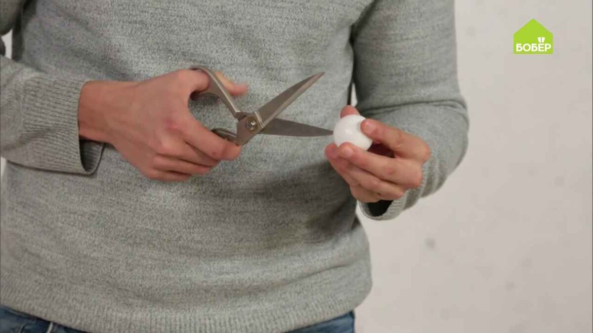 При помощи ножниц сделайте в шариках два отверстия, которые должны располагаться друг напротив друга.