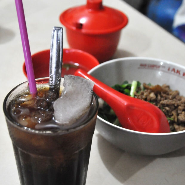 В кофейне Kopi Es Tak Kie (kopi es — «ледяной кофе») подают кофе со льдом вместе с жареным рисом/лапшой со свининой. Кондиционера нет, интерьер максимально простой, но поток клиентов и дружеская беседа не утихают в этой старой кофейне уже почти сто лет. Фото: post307.wordpress.com